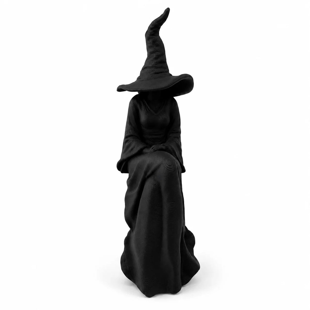 A black witch figurine with a pointed hat and flowing robes.