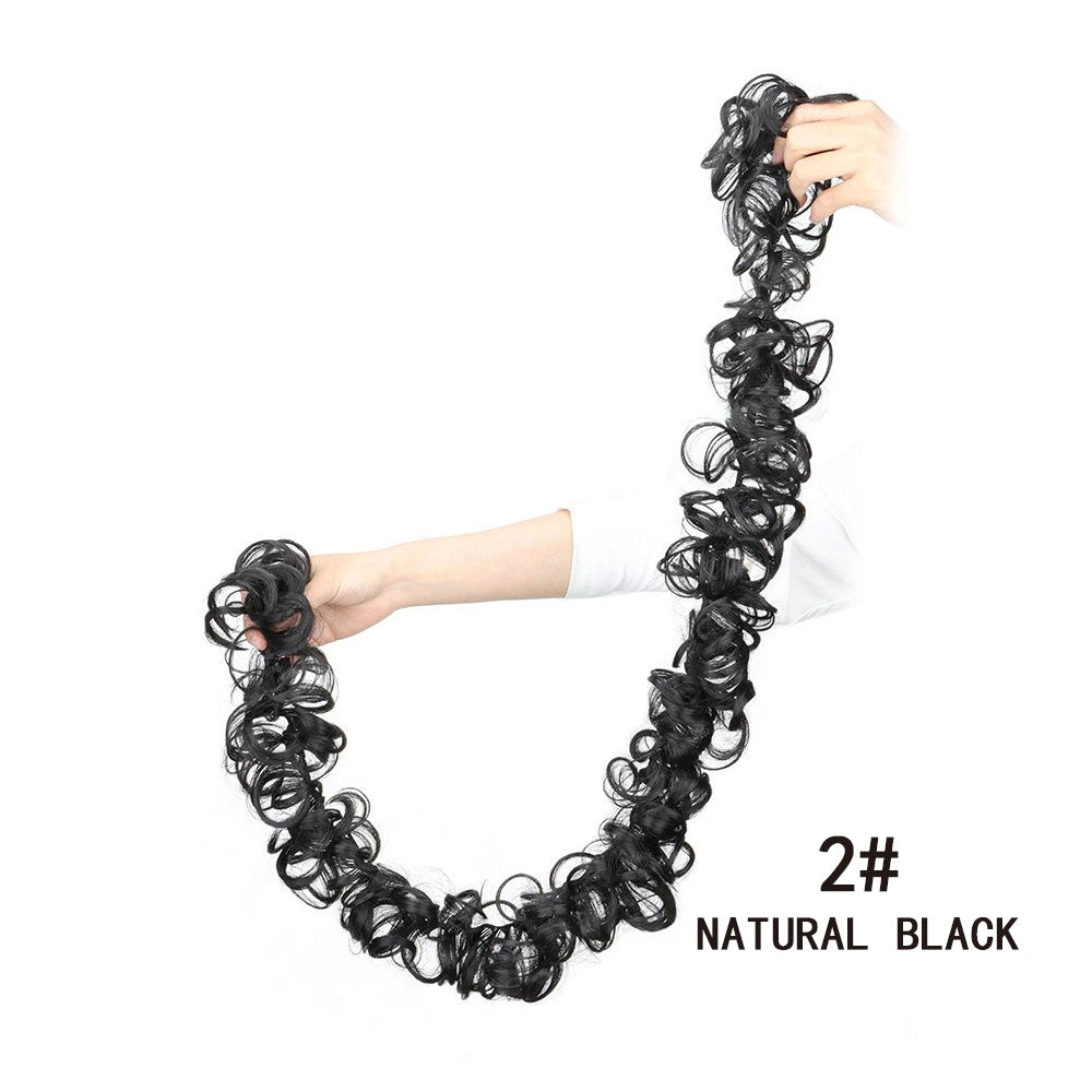 Un élastique de cheveux noir et synthétique, en scrunchie, montrant sa texture et sa taille.