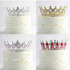 White tiered cake with crystal rhinestone crown toppers decorated with edible gold and silver accents