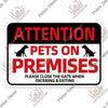 A black and red warning sign with a silhouette of a dog, stating ATTENTION PETS ON PREMISES and instructions to close the gat