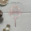 A pink acrylic cake topper set shaped like a geometric star with the words Happy Birthday