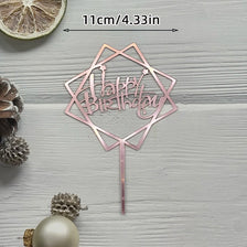A pink acrylic cake topper set shaped like a geometric star with the words Happy Birthday