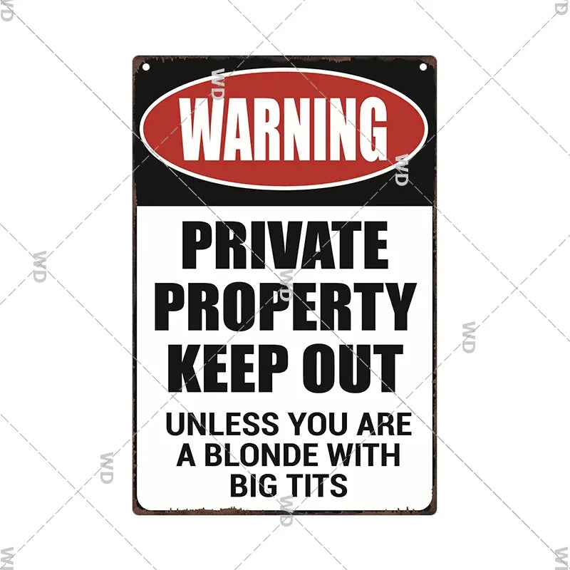 A vintage metal warning sign with a red oval banner that reads WARNING PRIVATE PROPERTY KEEP OUT UNLESS YOU ARE A BLONDE WITH