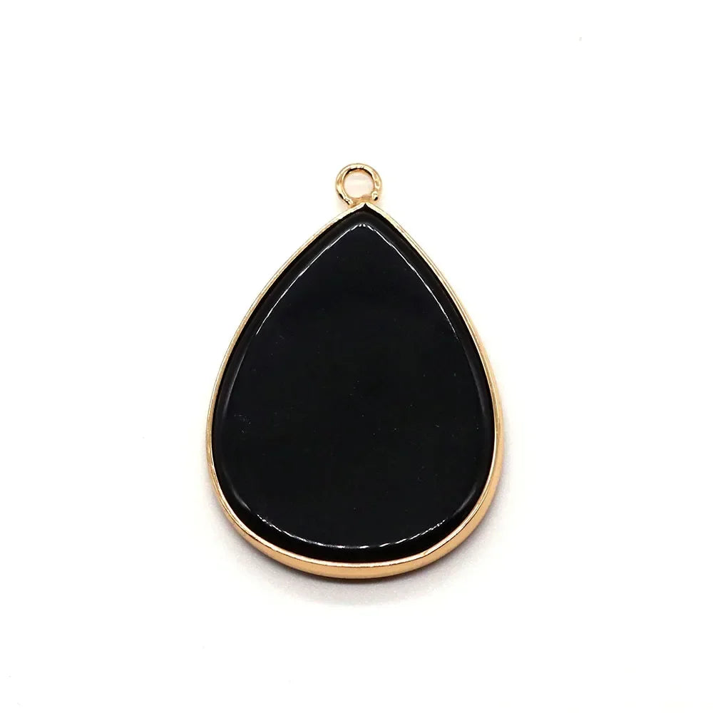 A black teardrop-shaped pendant charm with a gold-colored bail.