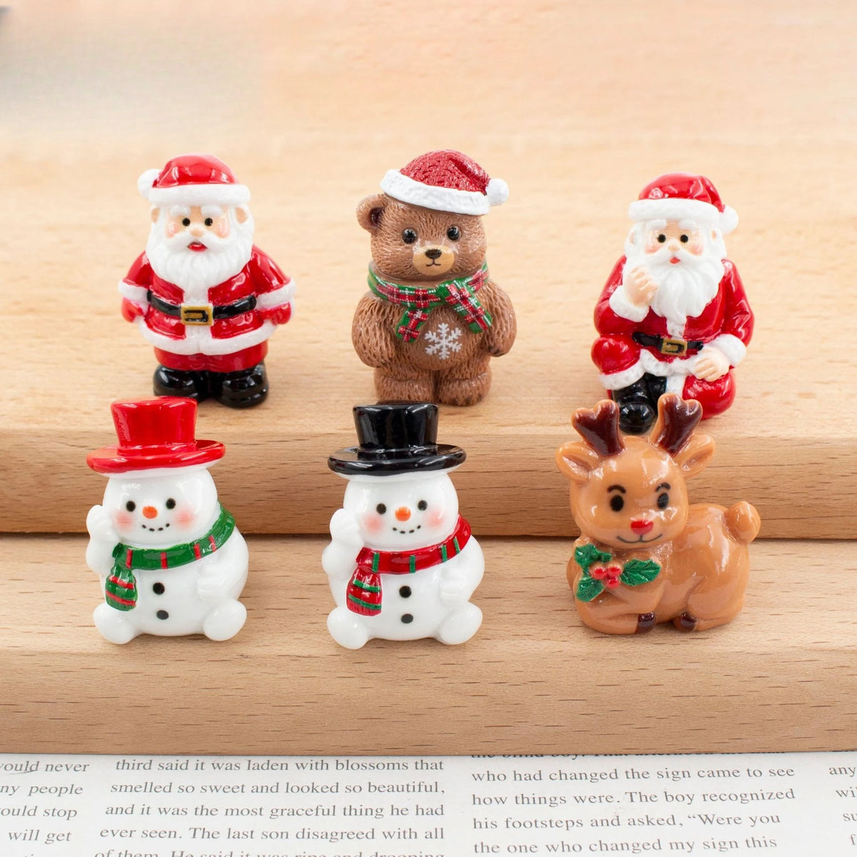 A set of festive Christmas resin decor featuring Santa, teddy bear, and snowmen figures.