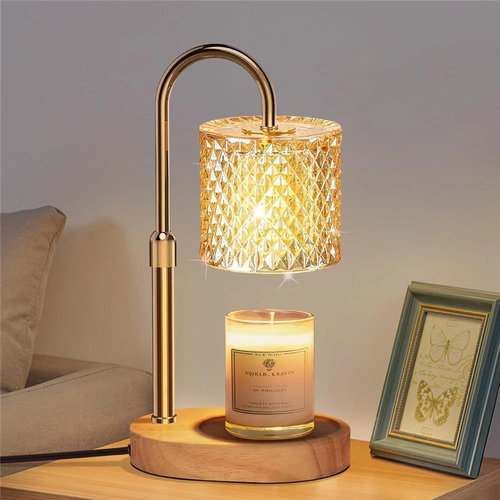 A brass adjustable heat candle warmer lamp with a textured glass shade sits on a wooden surface.