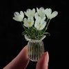 A hand-blown glass flower bouquet of white tulips in a clear glass vase.