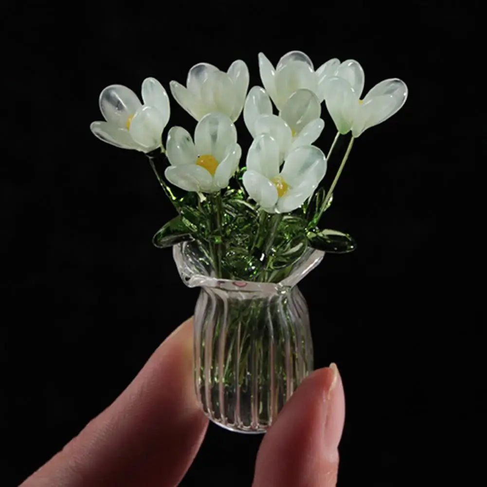 A hand-blown glass flower bouquet of white tulips in a clear glass vase.