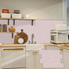A kitchen backsplash featuring light pink subway tile and wooden countertops with appliances.