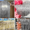 A display of sequin glitter party backdrops featuring pink and silver balloons and shimmering fabric curtains.