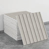 A stack of rectangular, light beige self-adhesive marble tile stickers shown from the side.