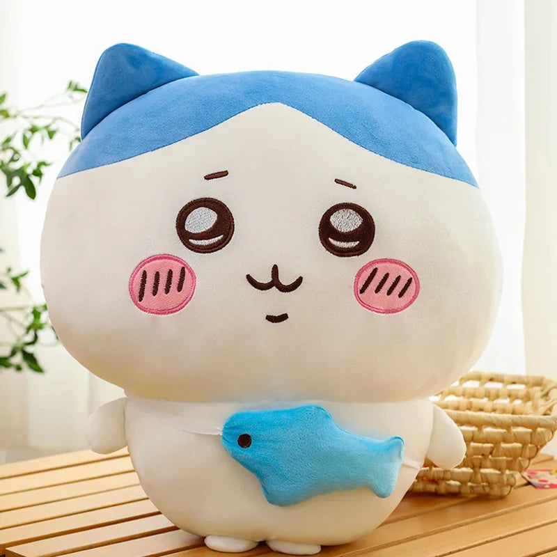 A white and blue Chiikawa Hachiware plush pillow featuring large eyes and pink cheeks.