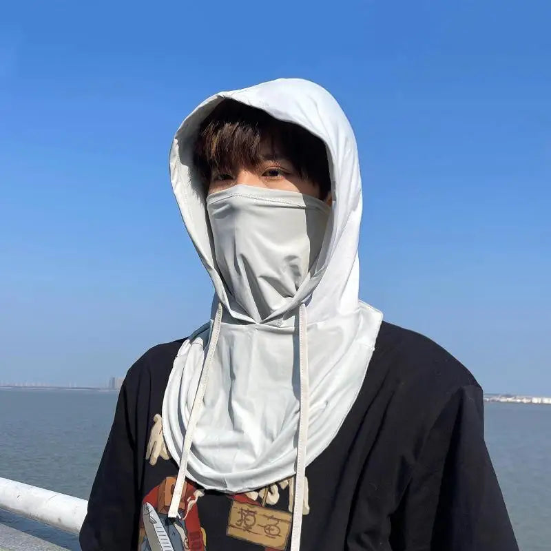 A person wearing a white breathable UV protection balaclava face mask and long neck cover against a clear blue sky.