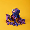 A dark blue and purple 3D printed tree frog ornament against a solid yellow background.