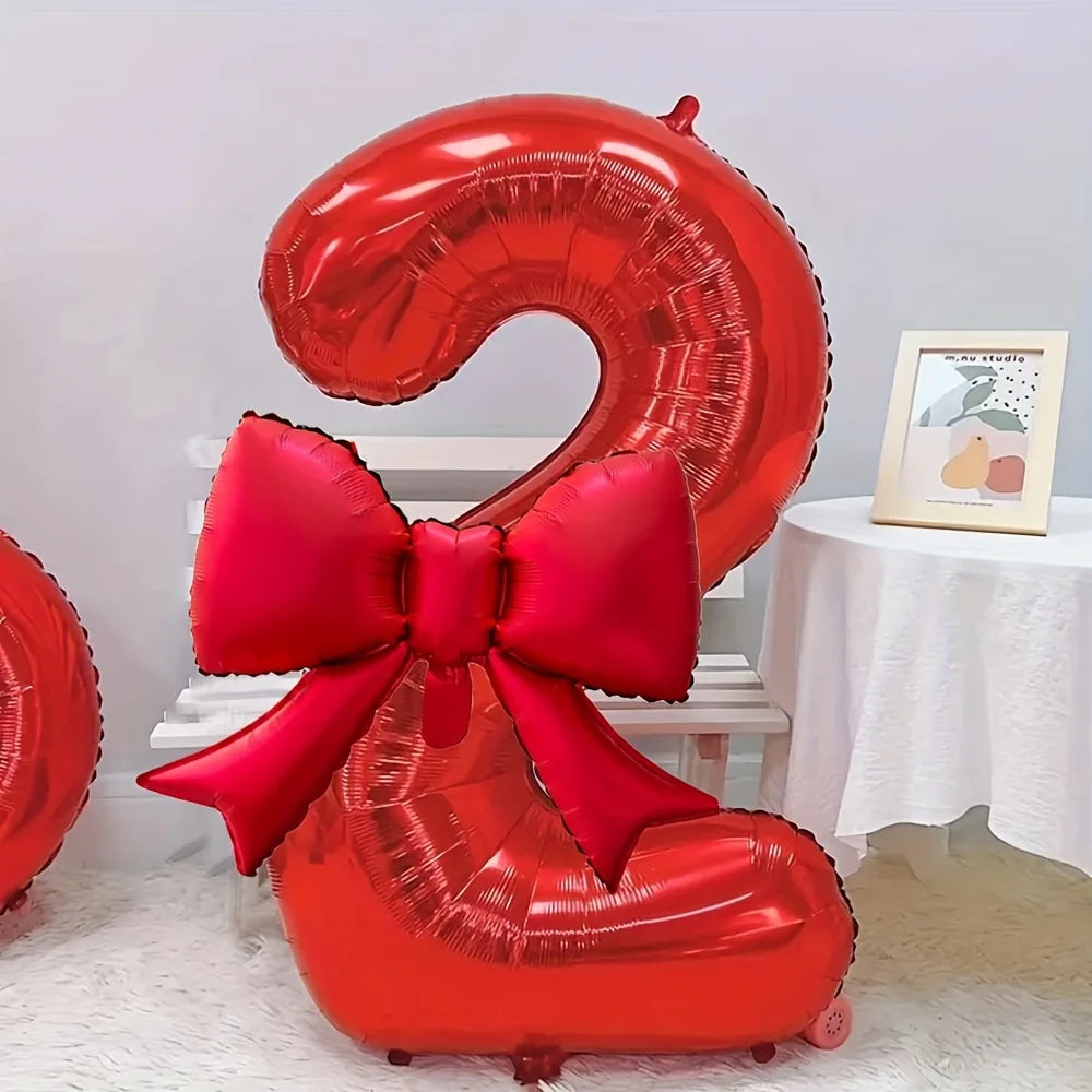A large red foil number balloon shaped like the number 2, tied with a matching red bow.