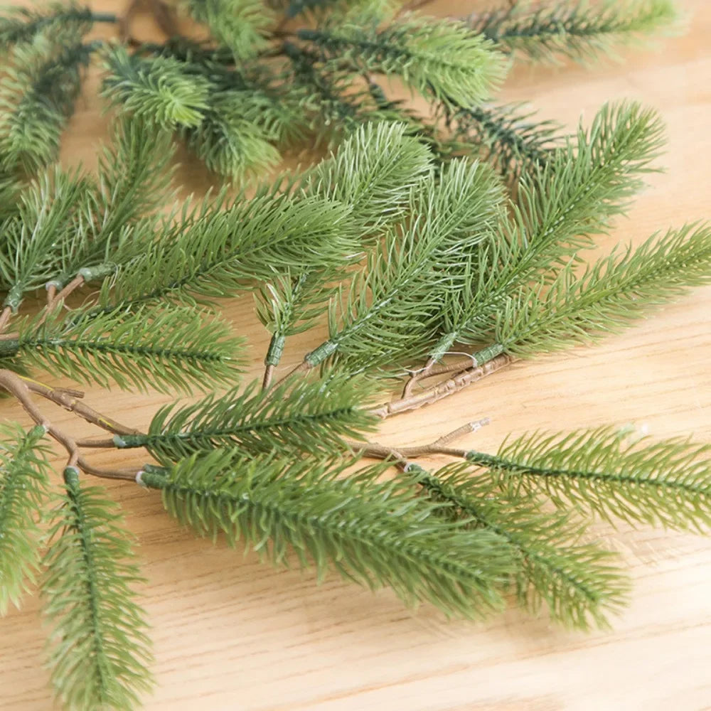 Green artificial pine garland branches on a wooden surface