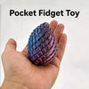 A hand holds a textured, iridescent purple and blue dragon egg fidget toy.