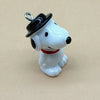 A white ceramic dog pendant wearing a black top hat and a red collar.
