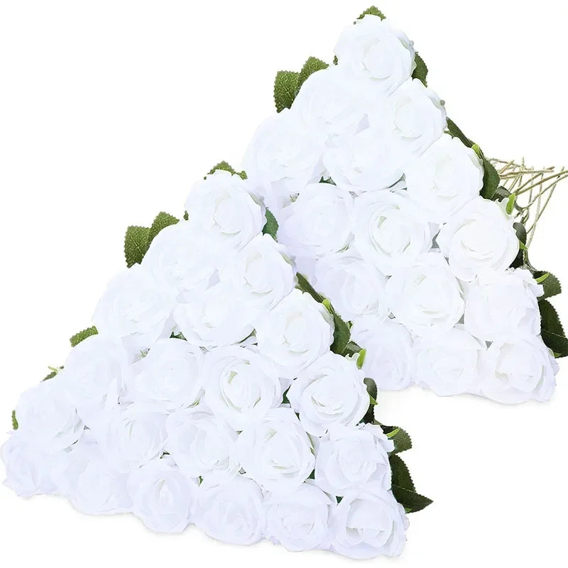 A bouquet of white velvet artificial roses with green leaves.