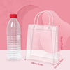Clear reusable PVC gift bags with handles displayed on a pink background.