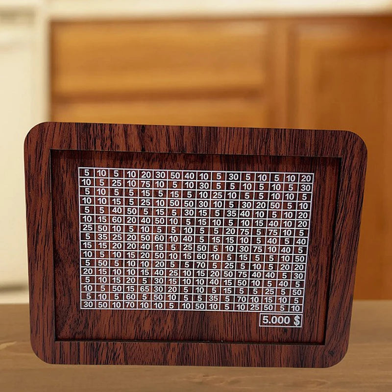 A wooden savings box with a progress tracker showing various dollar amounts.