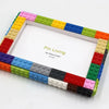 A colorful building block photo frame kit with a white border and various colored blocks surrounding the frame.