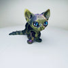 A detailed, articulated 3D printed figurine of a Siamese cat with iridescent purple and blue eyes.