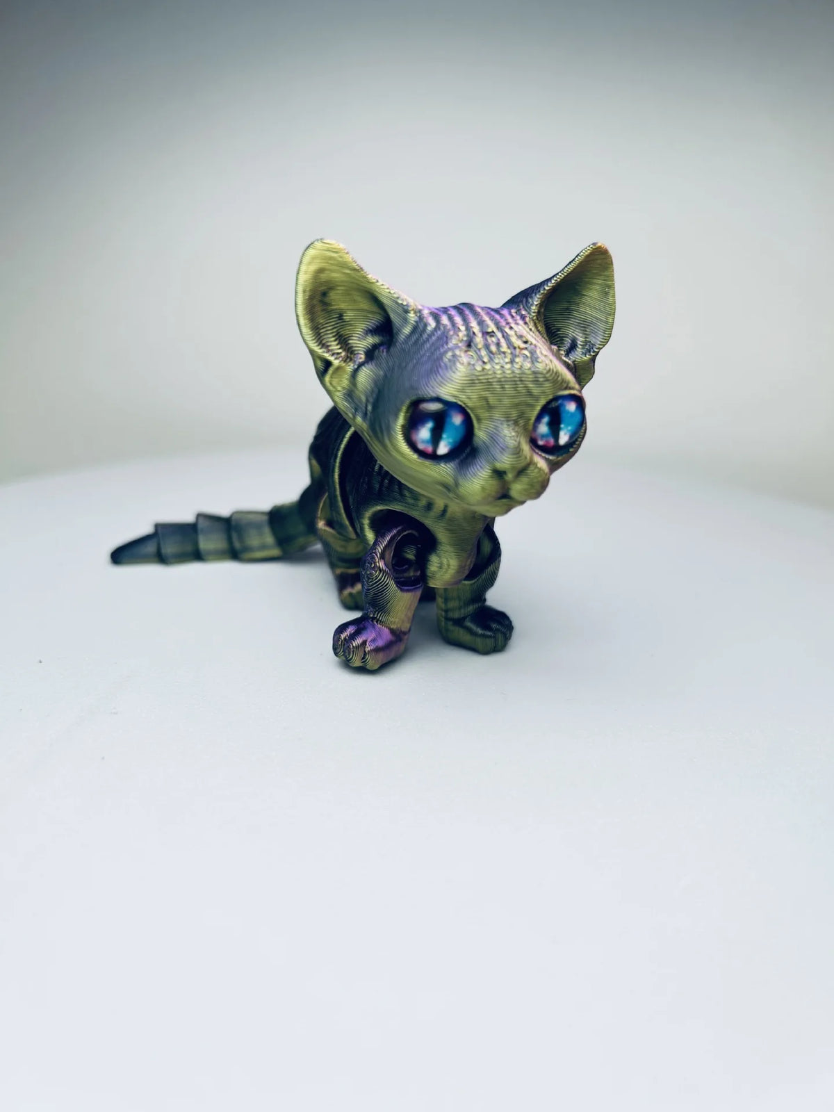 A detailed, articulated 3D printed figurine of a Siamese cat with iridescent purple and blue eyes.