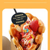 A close-up of a food item served in a disposable kraft paper cup, featuring fruit and toppings.