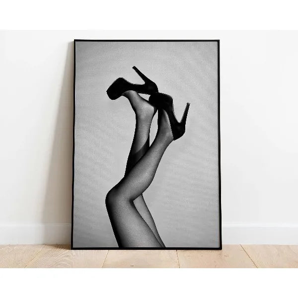 Black and white photograph of a woman's legs and feet wearing black high heels.