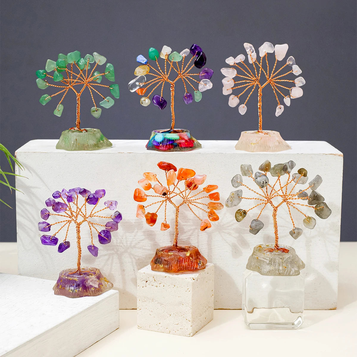 A display of seven chakra healing crystal trees featuring natural stones in various colors and textures.