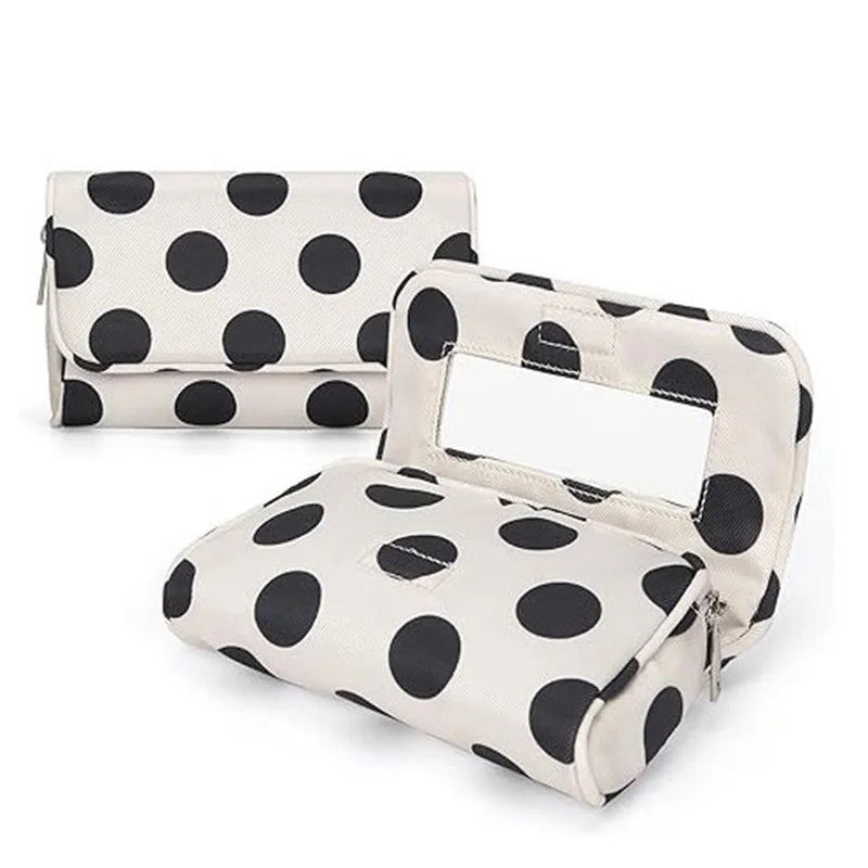 A portable canvas makeup bag with a mirror featuring a black polka dot pattern on a light background.