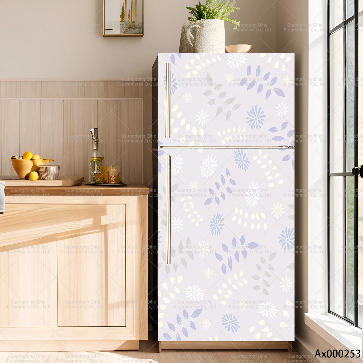 A modern, light gray refrigerator with a white floral decal on the door, set against a wooden cabinet and window.