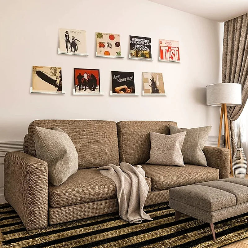 A display shelf featuring various vinyl records and album covers mounted on a white wall.