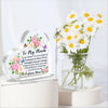 A heart-shaped acrylic plaque with 'To My Mum I Love You' engraved, displayed next to a bouquet of white and yellow flowers.