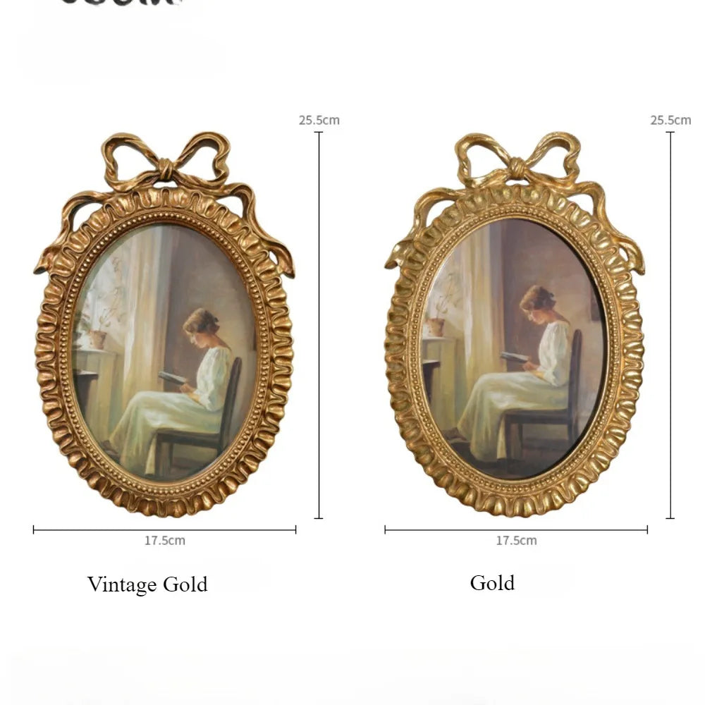 A vintage gold picture frame with a bowknot design, showing two framed paintings.