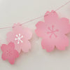 Pink paper cherry blossom flower flags hanging on a string