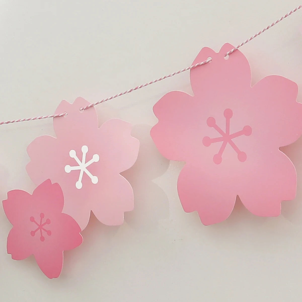 Pink paper cherry blossom flower flags hanging on a string