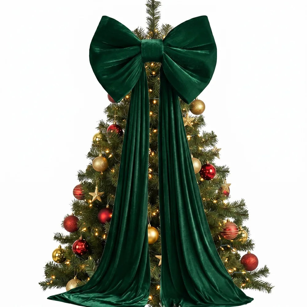 A deep emerald green velvet Christmas tree bow with long draping tails decorating a festive evergreen tree.