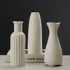 A white ceramic desktop vase with an organic ripple design shown in three different shapes and sizes.
