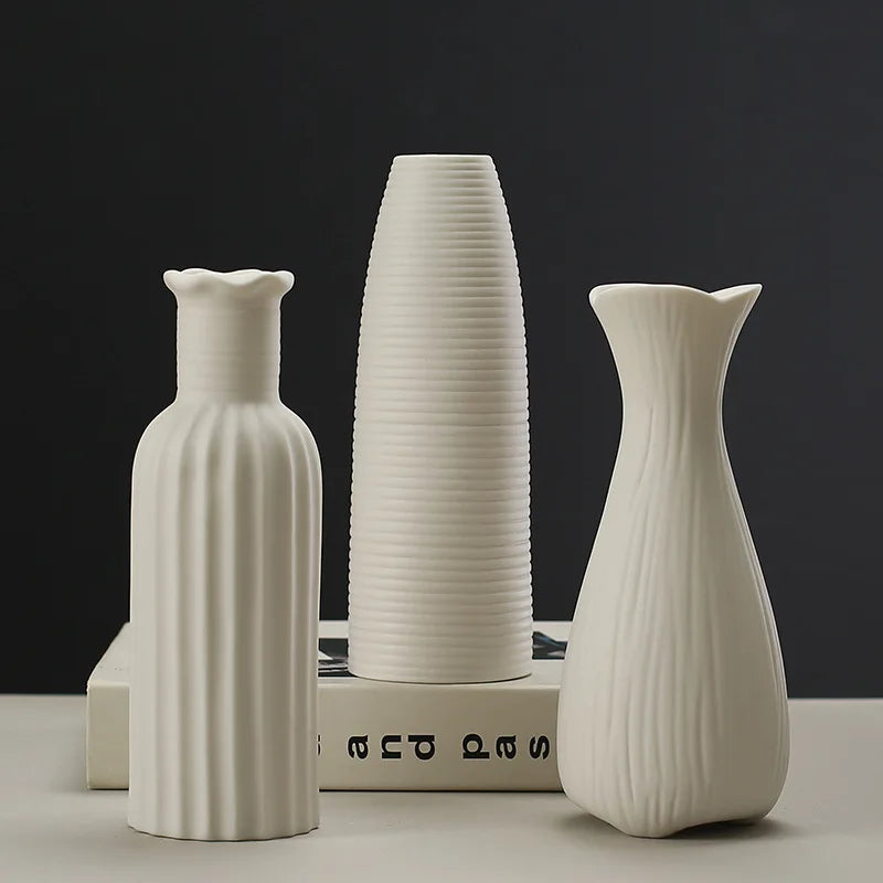 A white ceramic desktop vase with an organic ripple design shown in three different shapes and sizes.