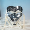 A silver masquerade mask with intricate floral patterns and a Hanfu-inspired design displayed on white fabric.