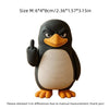 A black and white penguin desk statue with one flipper raised in a thumbs-up gesture.