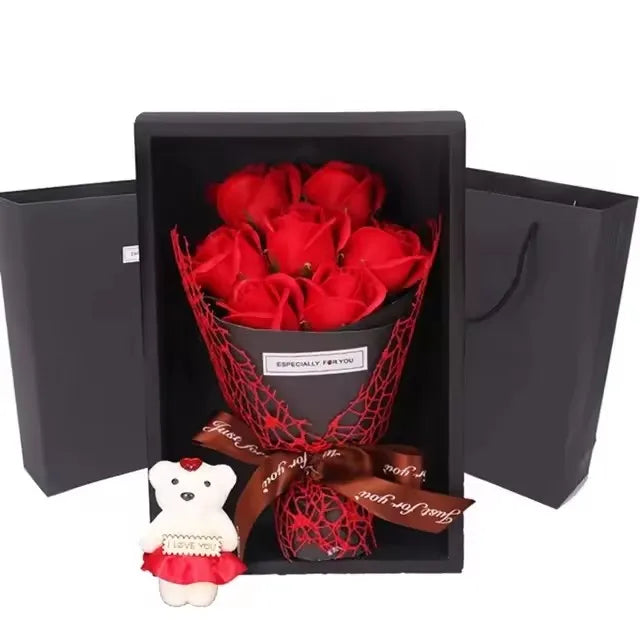 A gift box containing a red rose bouquet and a plush white bear.