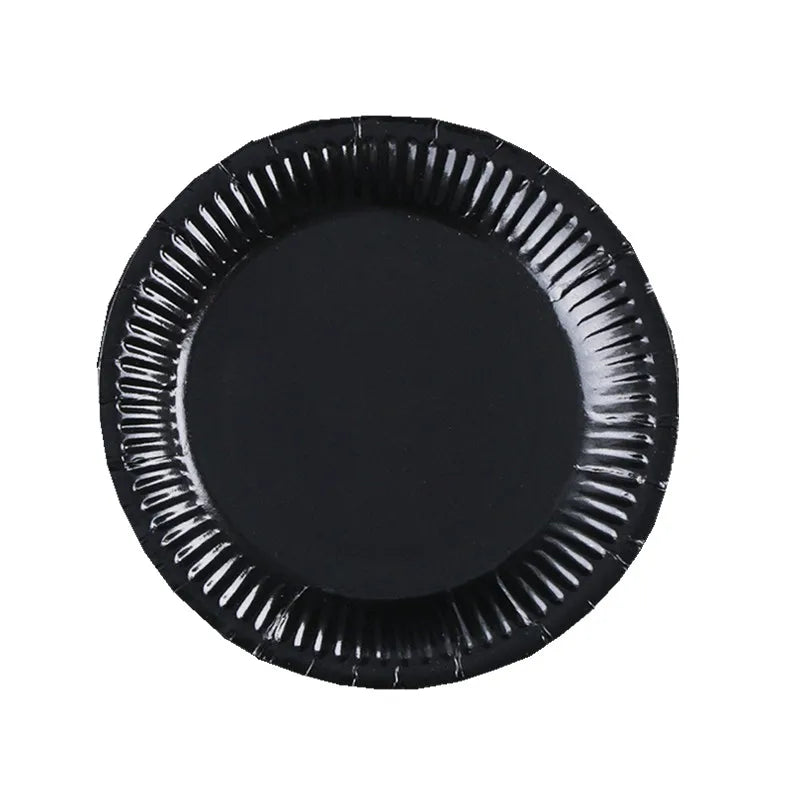 A black disposable plate with ruffled edges.