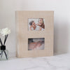 A light beige linen-covered photo album with two framed photos inside.