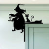 A black silhouette of a witch with a pointed hat and a broomstick, standing next to a cat and a silhouette of a bird on a whi
