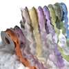 A collection of colorful decorative fishtail yarn ribbons in pastel shades displayed on a white surface.