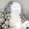 A display of round gray and white latex balloons forming a balloon arch with 'Happy Birthday' written in light glow.
