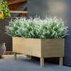A wooden planter filled with artificial white lavender stems for outdoor decor